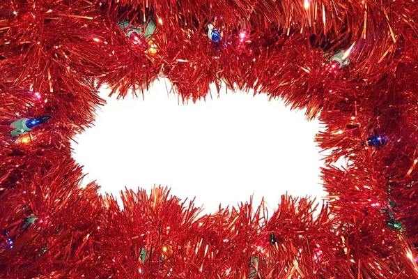 Işıklı beyaz zemin üzerine kırmızı Noel Tinsel Garland. Mutlu bayramlar ve Sezon selamlar çerçeve.