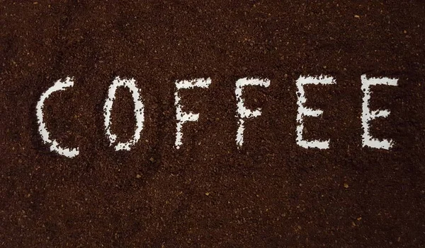 Coffee Spelled Out in Ground Coffee.  Coffee Grinds on White Background.  Coffee Art and Craft.