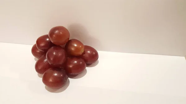Kırmızı üzüm sanat ve el sanatları. Sanatsal meyve tasarım. Piramit şeklinde beyaz arka plan üzerinde.