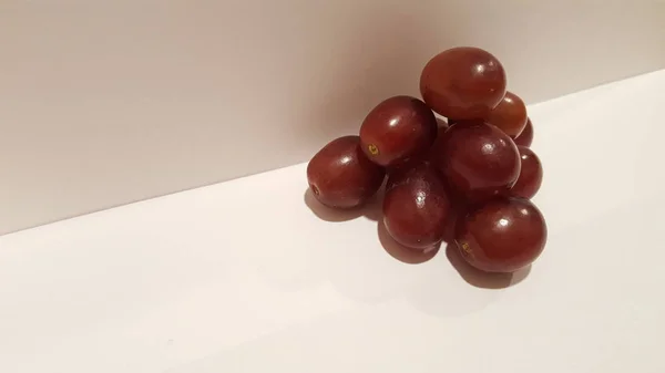 Kırmızı üzüm sanat ve el sanatları. Sanatsal meyve tasarım. Piramit şeklinde beyaz arka plan üzerinde.