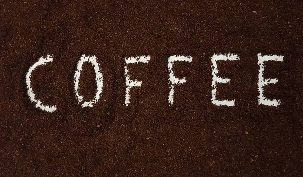 コーヒーは挽いたコーヒーで綴られています 白い背景にひいたコーヒー コーヒー アートとクラフト ストック写真