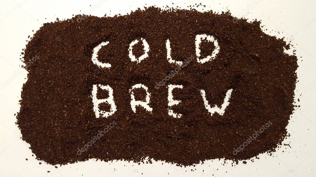 Cold Brew Spelled Out in Ground Coffee.  Coffee grinds on White Background.  Cold Brew Coffee.
