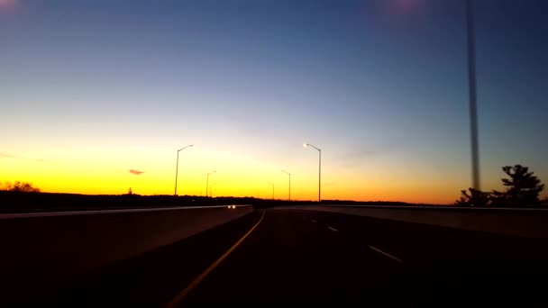 日出时驾驶乡村公路 司机的观点波 而太阳在地平线上升清晨 — 图库视频影像