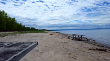 Güzel Kum Sahil Shore Boyunca Piknik Masası. Güzel Mavi Gökyüzü ile Yaz Günü Güneşli Tatil Shoreline Beach Hedef.
