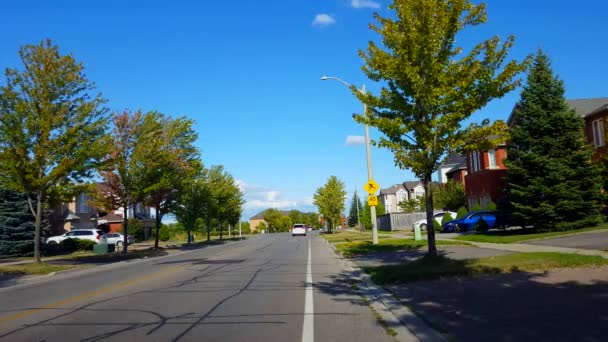 車両交通のある郊外市街地の視点夏の日中の住宅郊外住宅沿いの都市道路 — ストック動画