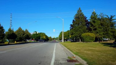 Yaz aylarında Bisikletçi ile Şehir Caddesi Kavşak Trafik. Yol Kavşağından Geçen Ve Gün Bisiklete Binen Kişi Ile Kentsel Peyzaj.