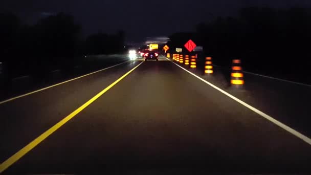 ドライビングレーンは 夜間に建設マーカーの標識で農村道路を終了します 夕方に田舎の通りを運転しながら ビューポブオレンジ注意道路標識のドライバーの視点 — ストック動画