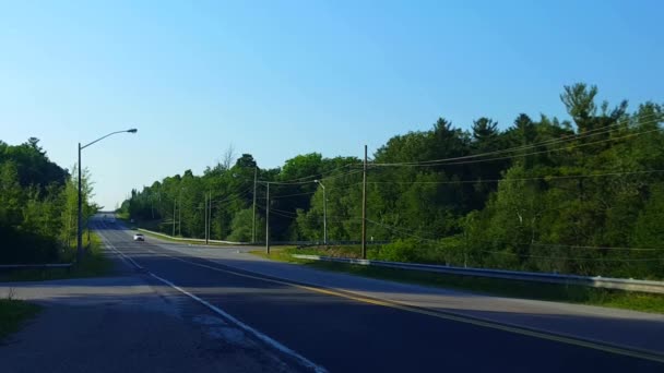 自動車道路の長いストレッチをオフにします 夏の日のツリーンストリートから左折する車 — ストック動画