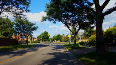 Kırmızı ışıkta araç bekliyor. Işık yeşile dönüyor ve araç yazın City Banliyö Işıkları kavşağından sola dönüyor. Şehir Trafik Işıkları Kavşağında Otomobil Yeşil Işık İçin Bekliyor.