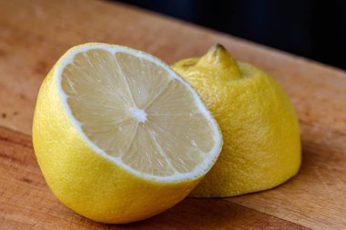 İki yarım limon kesme tahtası üzerinde yalan.