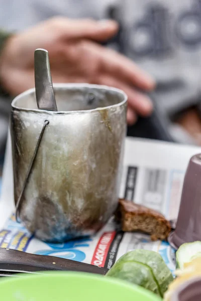 Eski balık tutma veya pot bir adam arka plan üzerinde avcılık elinden, bir parça kuru ekmek ve masanın üzerinde yatan eski bir gazete.