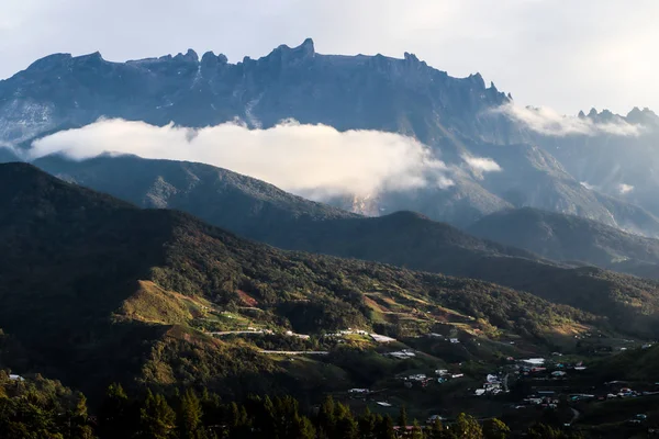 Görkemli mount Kinabalu içinde belgili tanımlık geçmiş ile küçük köy görünümü
