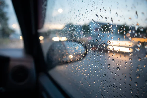 Rain drop on the window with light trail