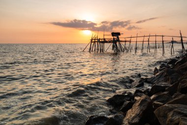 Altın saat sırasında kayalık sahil ile ahşap İskelesi