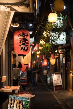 Ön planda Japon kelime yazılı fener ile Omoide Yokocho sokak görünümü. Dikey oryantasyon.