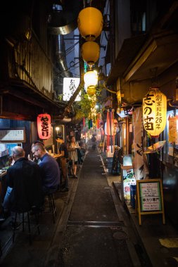 Gece Omoide Yokocho 'da sokak görünümü. Geleneksel Japon binası. Dikey oryantasyon.