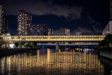 Yokohama 'da gece vakti binayı kanala bağlayan fotbridge görüntüsü.
