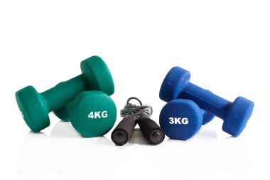 Yeşil ve mavi dumbbells ile beyaz bir arka plan üzerinde izole bir atlama ipi.