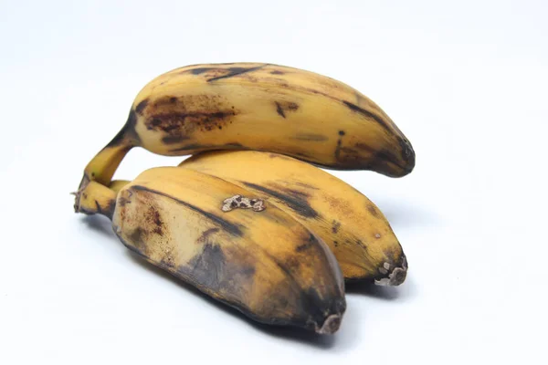 Cildinde siyah lekeler olan olgun bir muz. Beyaz arkaplanda izole edilmiş eski muz