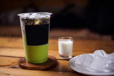 Süt ve çimen jölesi karışımı koyu arkaplanlı guava buzu. Meyve aromalı soğuk içecekler. Plastik bardaklarla renkli buz modelleri