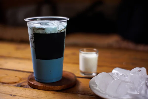 Süt ve çimen jölesi karışımı koyu arkaplanlı buzlu şeker. Meyve aromalı soğuk içecekler. Plastik bardaklarla renkli buz modelleri