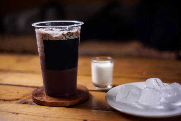 Süt ve çimen jölesi karışımlı koyu arkaplanlı çikolatalı buz. Meyve aromalı soğuk içecekler. Plastik bardaklarla renkli buz modelleri