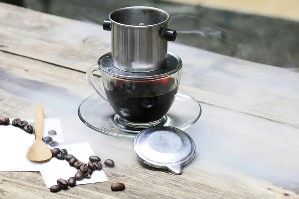 木製のカフェテーブルの上にベトナムコーヒーを1杯 まだ暖かいコーヒーをすすいで コーヒーは昼休みに ストックフォト
