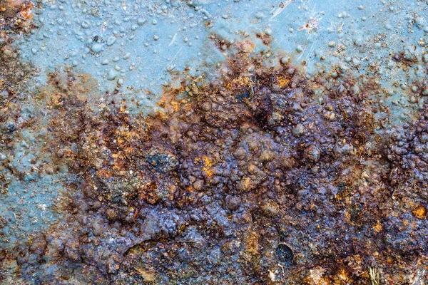 rusting old metal plate painted with blue paint