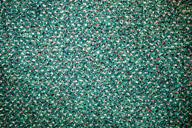 Beyaz, kırmızı ve siyah noktalı yeşil yün kumaş.