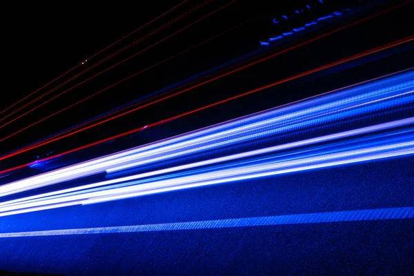 Geceleri hareket halindeki arabaların ışıkları. uzun pozlama