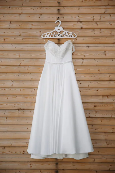 bridesmaid dress hanging on a wooden wall in a yacht club on the background of white yachts