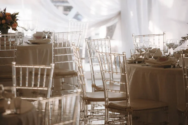 translucent chairs in the wedding tent are the decoration of any wedding ceremony