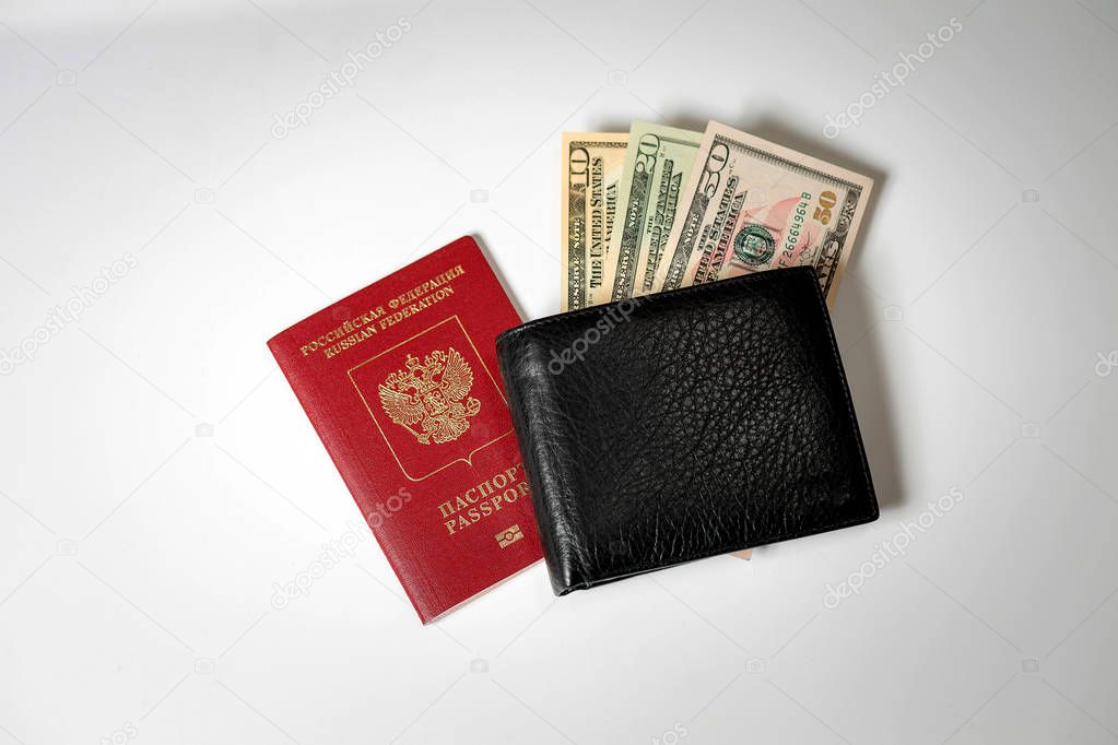 dollar bills in a black mens wallet on a white background and a passport of the Russian Federation