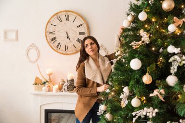 Mutlu kutlamalar. Güzel kadın yeni yıl kutluyor. Kutlama kız Noel ağacı yakınındaki