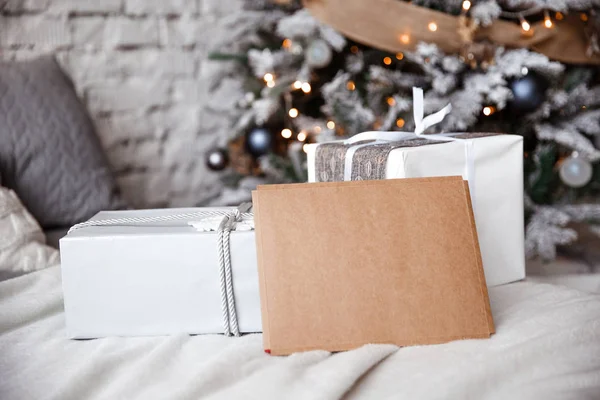 クラフト封筒はクリスマス ツリーの背景でベッドに横たわっています — ストック写真