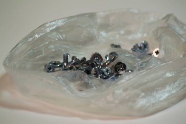 Plastik torbada kısa cıvatalar ve fındıklar.