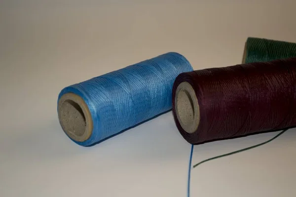 Rouleaux de fil rouge avec aiguilles. Bleu, lilas, vert — Photo