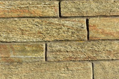 Kaba doku. Taş tuğla bir duvar günbatımı ışığı ile. Yatay ve dikey çizgiler.