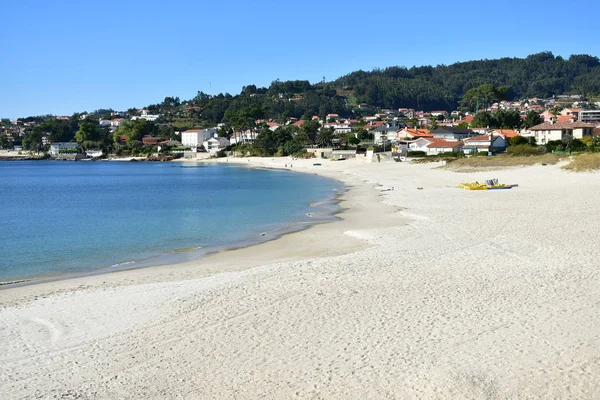 明るい砂とターコイズ ブルーの水とビーチ 海岸沿い村 青い空 ガリシア スペイン — ストック写真