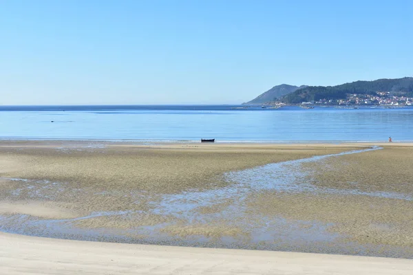 濡れた砂のビーチは 水の青とボートをオフします 小さな沿岸村 ガリシア スペイン 晴れた日に 青い空 — ストック写真