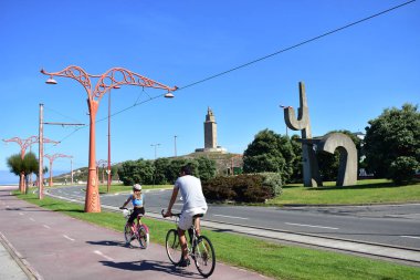 Baba ve kız bir mesire Bisiklete binme. La Coruna, Herkül Kulesi Parkı. Şehir ve doğa. İspanya. güneşli bir gün, mavi gökyüzü.