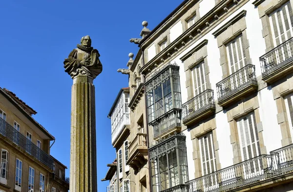 stock image Santiago de Compostela, Cervantes Square. Cervantes Column and houses. Blue sky, sunny day. Spain.