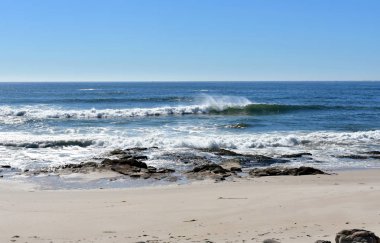 Vahşi plaj kayalar ve dalgalar breaking. Deniz köpüğü ile mavi, gök temizleyin. Güneşli bir gün, Galiçya, İspanya.