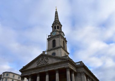 Trafalgar Meydanı'na alanları kilisede St Martin. Neoklasik cephe ve sivri kule, mavi ve altın saat. London, Büyük Britanya.