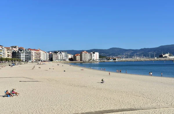 ビーチでの日光浴の人 明るい砂浜と青い海 晴れた日に サンシェンショ ガリシア スペイン 2018 — ストック写真