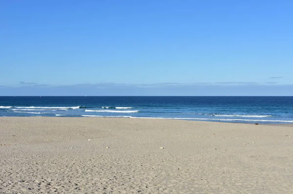 Пляж Золотым Песком Синим Морем Мелкими Волнами Пеной Чистое Небо — стоковое фото