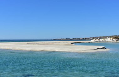 Plaj turkuaz su ve göl. Parlak kum tepeleri ve mavi deniz. Açık gökyüzü, güneşli bir gün. Galiçya, İspanya.