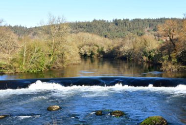 Nehir şelale, orman ve su yansımaları ile. Ponte Maceira, Coruna, İspanya.