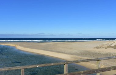 Nehir, ahşap korkuluk ve dalgalar ile Plaj. Mavi gökyüzü, güneşli gün, Galiçya, İspanya.