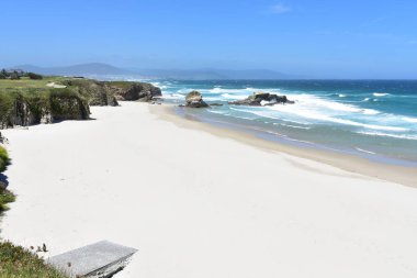 Beyaz kum, uçurum ve dalgalar ile plaj. Lugo, İspanya.